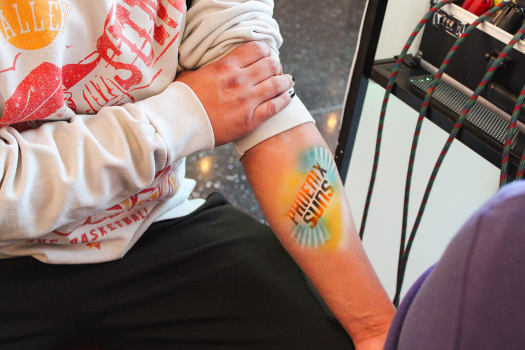 Airbrush temporary tattoo on a woman's forearm at an Arizona party